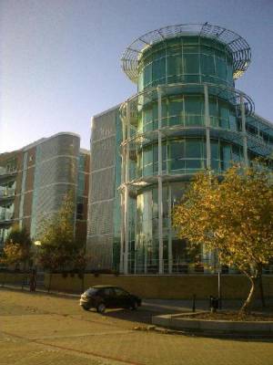 One corner of a Milton Keynes building, cylindricly shaped and glass faced, with walkways around it on several floors.