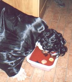 Picture of a dracula bobbing for apples floating in a blood red liquid